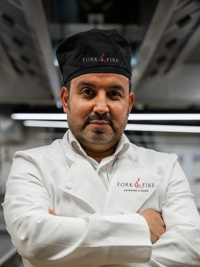 Abdullah Esmati in Kochjacke in der Produktionsküche